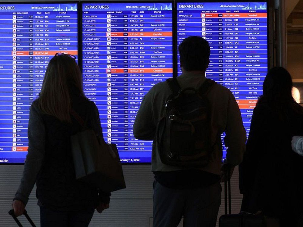 Travellers_look_at_a_flight_information_board_at_Ronald_Reagan_Washington_National_Airport_in_Arling.jpg