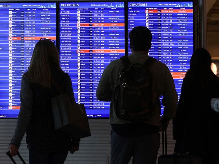 Travellers_look_at_a_flight_information_board_at_Ronald_Reagan_Washington_National_Airport_in_Arling.jpg